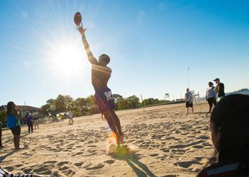 UB students playing football on the beach